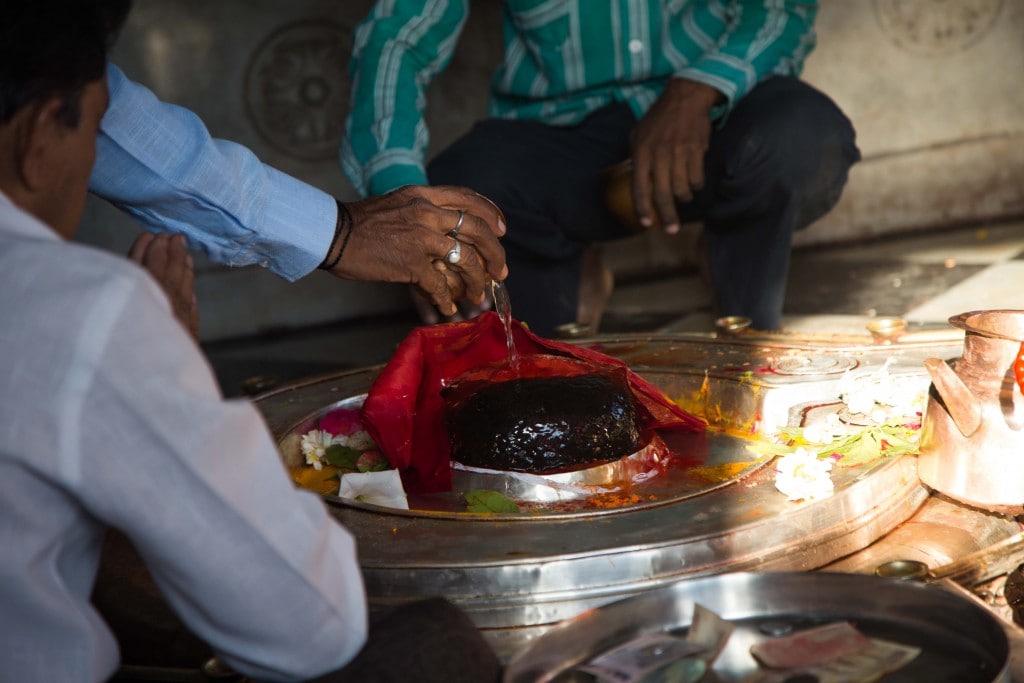 Devotees offer holy water to a Siva Linga