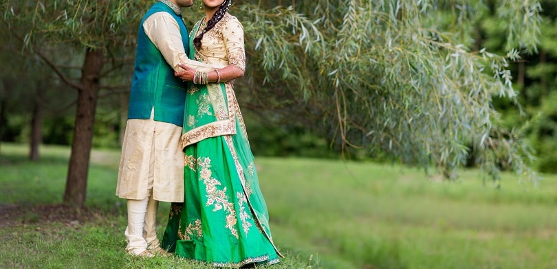 Photo of Contrasting bride and groom outfits in red and peach | Groom outfit,  Indian wedding outfits, Couple wedding dress