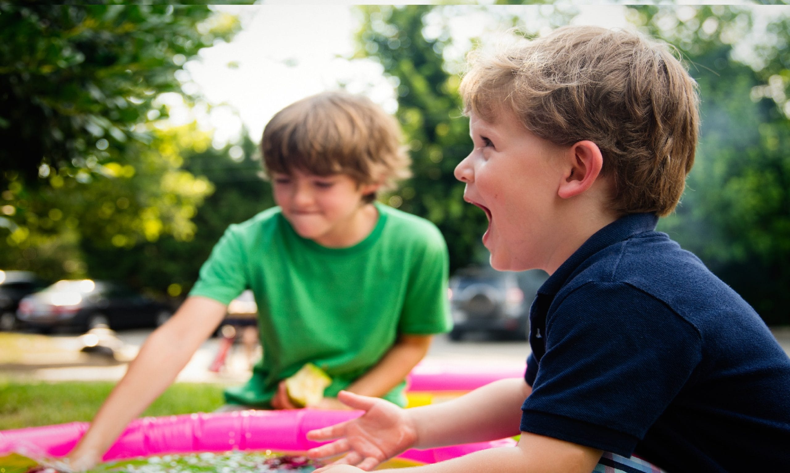 Dois meninos em um passeio de criança brincando em um parque.