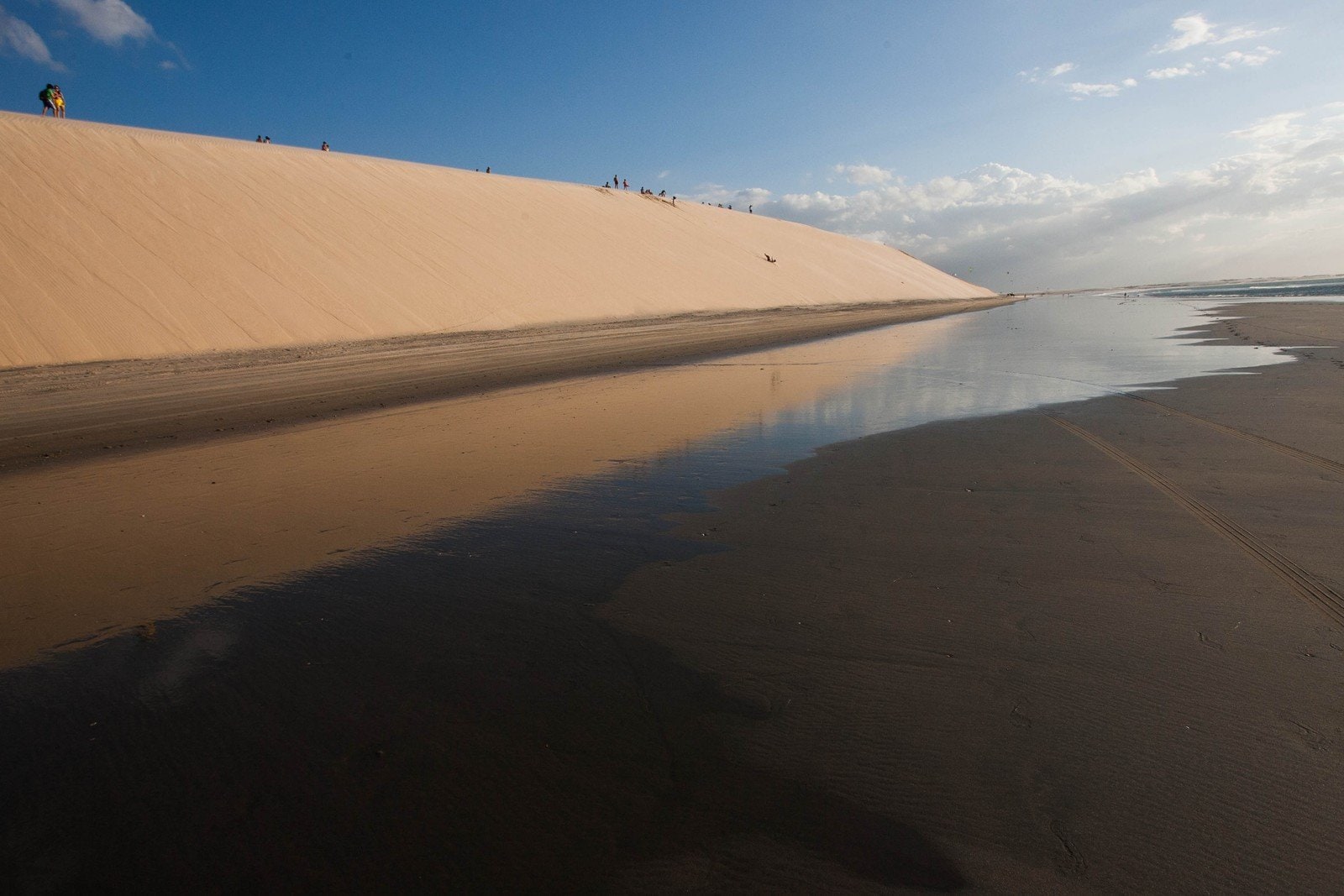 Jericoacoara, uma das praias encantadoras em fortaleza. A imagem mostra o céu espelhado na água e areia.