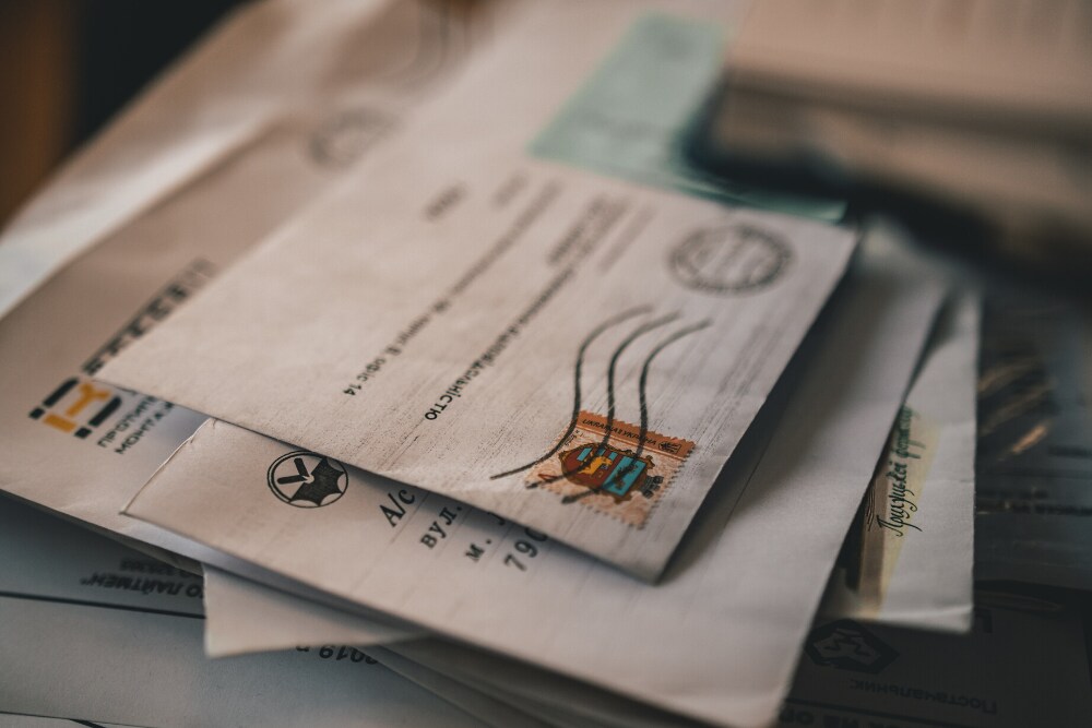 Imagem focada em uma pilha de envelopes, indicando os documentos necessários para viajar
