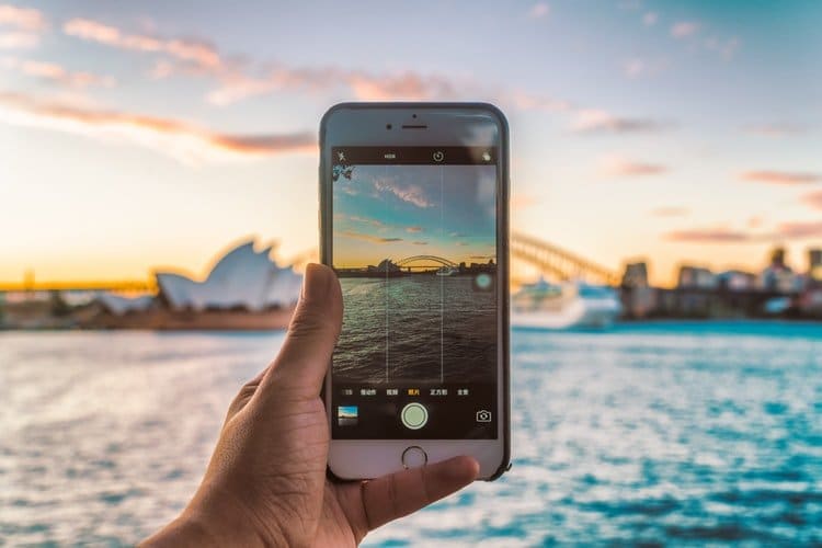 fotografia de um smartphone fotografando uma paisagem após aprender tudo sobre como tirar fotos perfeitas